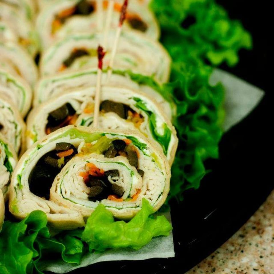 Ruby K's Bagel Cafe's catering platter of turkey and olive pinwheel wraps with lettuce.
